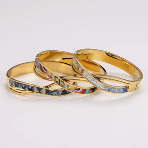 Three stackable gold-plated stainless steel bangles with colorful enamel cross patterns