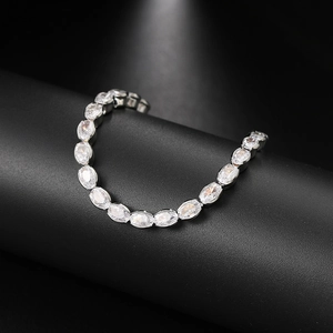 Elegant silver-tone tennis bracelet featuring oval-cut cubic zirconia on a black stand