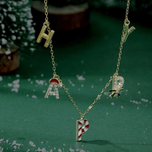 Close-up of golden S925 silver necklace with HAPPY letters and Christmas candy cane design