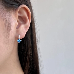 Close-up of S925 sterling silver hoop earrings with square blue zircon on model ear
