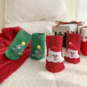 Detail of Christmas socks with 3D plush Santa Claus and festive tree decorations