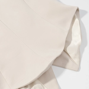Close-up detail of beige blazer sleeve with smooth texture and high-quality inner lining