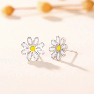 Close-up of elegant white daisy flower stud earrings with yellow centers and silver base