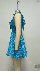 Detail of blue floral mini dress featuring ruffled neckline and smocked elastic waist