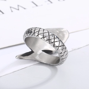 Macro shot of silver snake ring featuring detailed scales and green eye gemstone inlay