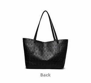 Back view of the black tote bag featuring embossed skull patterns on matte leather