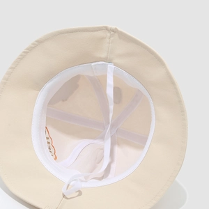 Detail of beige cotton bucket hat interior with sweatband and adjustable chin strap