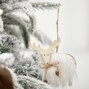 White wool and wood reindeer Christmas ornament hanging on a snowy tree branch