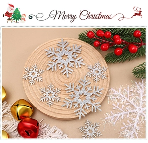 Glittering silver snowflake ornaments and red berries on a rustic wooden tray decoration