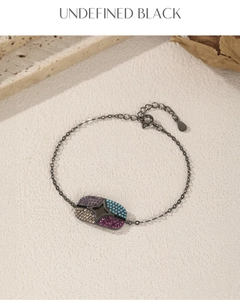 Detail of black metal starburst bracelet with multicolor gemstones and adjustable clasp