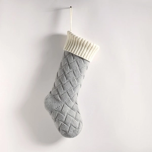 Close-up of grey and white knitted Christmas stocking with intricate woven texture