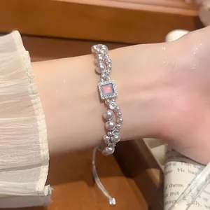 Élégant bracelet en perles et zircon avec pendentif en cristal rose sur poignet féminin