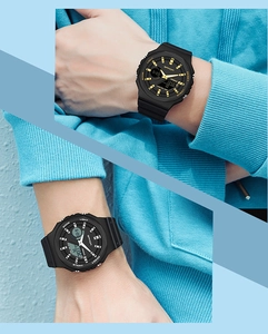 Close-up of SANDA black dual display waterproof watch on wrist with blue background