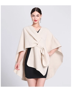 Front detail of beige knit poncho featuring an elegant front knot and soft draped texture