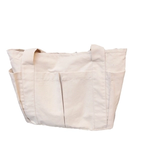 Minimalist cream canvas tote bag with multiple front pockets for daily commute and storage