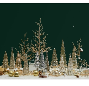 Detailed view of glass Christmas trees in gold and silver on white fur background
