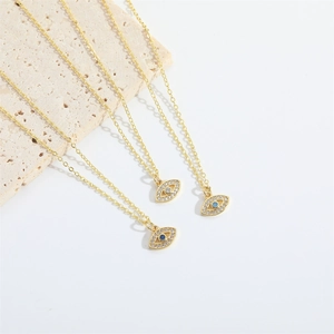 Three dainty gold evil eye pendant necklaces with sparkling blue and clear zircon crystals