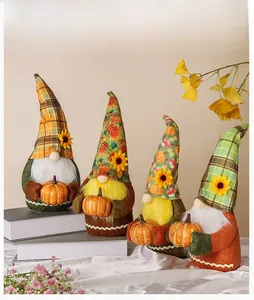 Detail view of 4 autumn gnomes with sunflower hats and mini pumpkins for fall decor