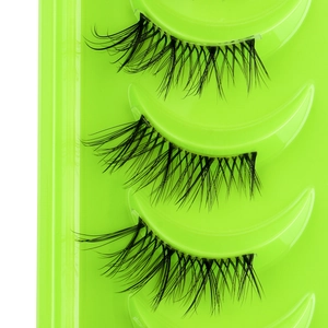 Macro detail of natural wispy half eyelashes with thick black band on green tray