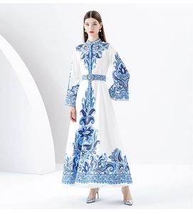 Detail of elegant paisley print on white long dress with mandarin collar and flared sleeves