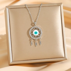 Bohemian silver evil eye necklace with dreamcatcher feather pendants on silk background