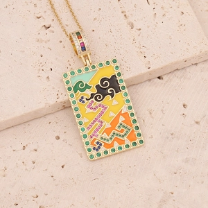 Macro view of gold tarot necklace with enamel rectangular pendant and zircon inlays