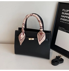 Close-up of black PU leather tote bag with silk scarf handle and golden twist lock