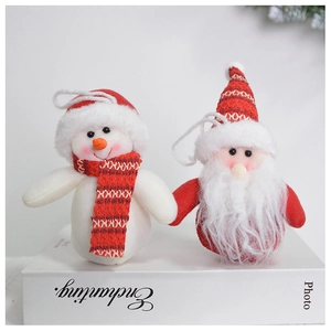 Detail view of plush snowman and Santa figurines on a decorative white book background