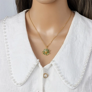 Elegant gold titanium steel necklace with a green daisy pendant on a white collar