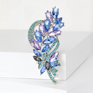 Macro detail of silver alloy brooch with multicolored crystal wheat branch design