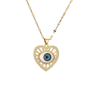 Gold evil eye heart necklace with blue center and white zirconia stones on white backdrop