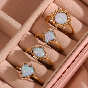 Detail of 18K gold plated opal ring set featuring sunflower and heart shapes in velvet box