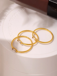 Detailed close-up of three gold-plated stackable rings with rectangular cubic zirconia stones