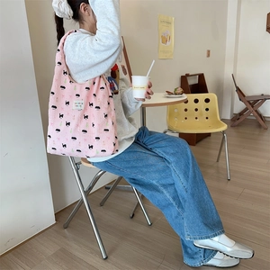 Detailed shot of a pink puffy tote bag with bear patterns in a cafe setting