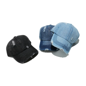Three distressed washed denim baseball caps with ripped details in black, dark and light blue