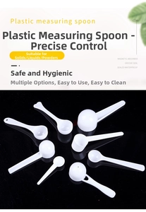 Macro view of white plastic measuring spoons set with round and heart shapes