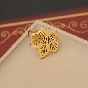 Macro shot of gold maple leaf ring on a jewelry box lid with selective focus