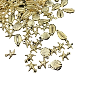 Golden sea shells and starfish charms pendants for DIY jewelry making on white background