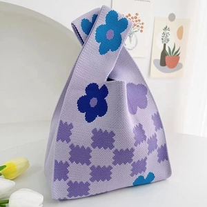 Detail of purple knitted tote bag with blue floral pattern and checkered design