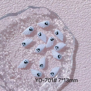Close-up of YD-701 white resin ghost nail charms with black smiles on pink background
