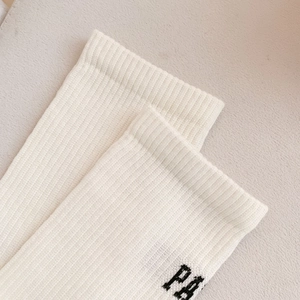 Detail of white ribbed cotton sock featuring black gothic PA letter embroidery