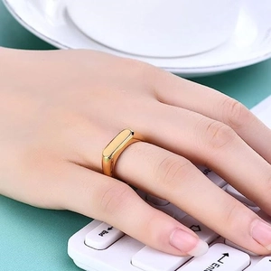 Detail shot of a minimalist gold rectangle flat top ring on a finger with sleek polished finish