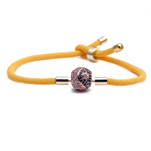 Adjustable yellow braided rope bracelet with a gold-plated yin yang charm and micro-inlay