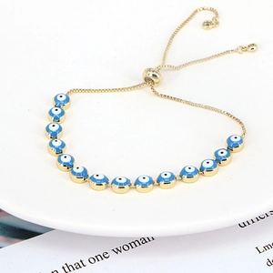 Detailed view of bohemian gold evil eye bracelet with blue charms and adjustable slide clasp