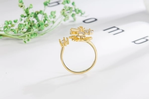 Detail macro shot of a golden spinning windmill flower ring with sparkling zircon stones