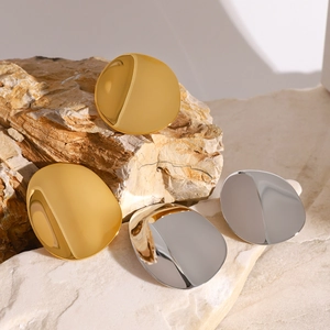 Polished stainless steel concave geometric stud earrings on a natural stone surface