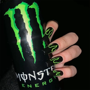 Close-up of long square black nails with neon green flame design and glossy finish
