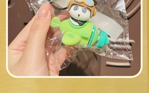 Dettaglio di un simpatico panda pilota su un aereo verde con cinturino in PVC