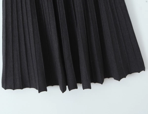 Nahaufnahme der plissierten schwarzen Stofftextur und des elastischen Bunds am Maxirock