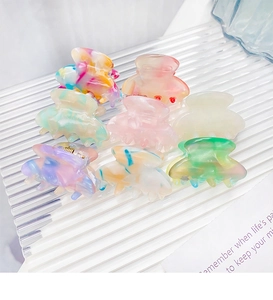 Set of eight colorful mini acetate hair claws with elegant marble patterns and gold springs